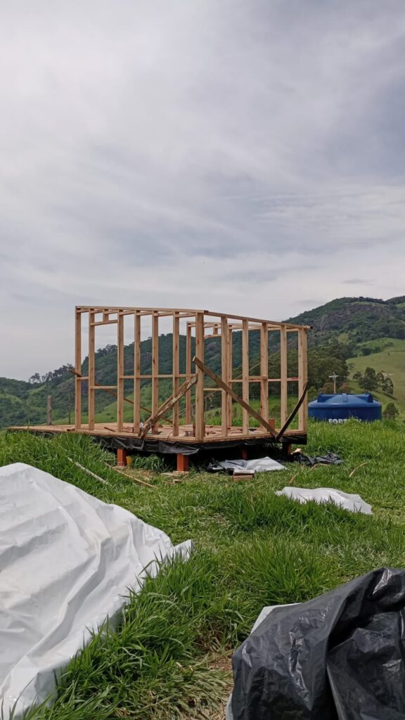 Off-grid tiny cabin wall frame under construction in rural landscape