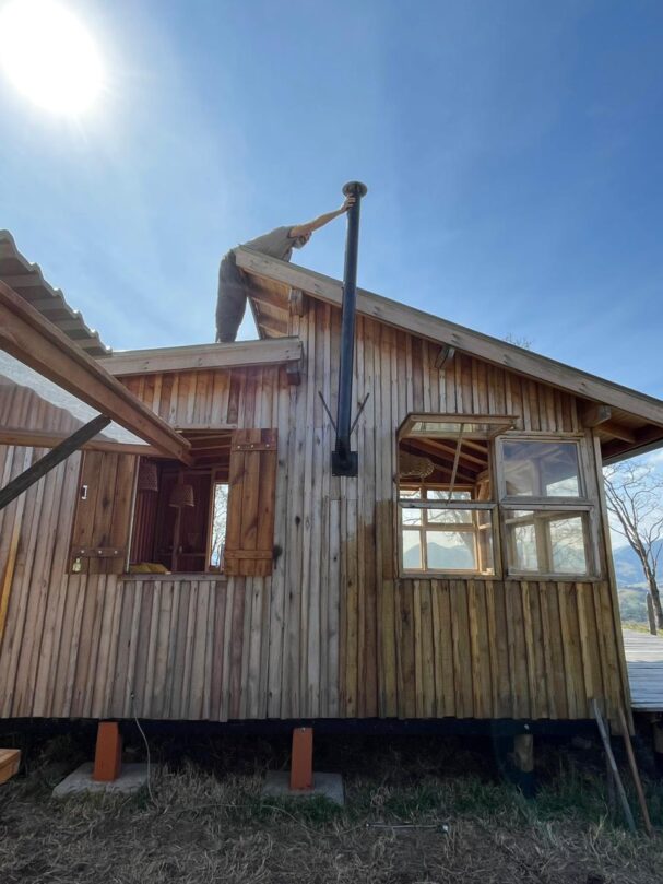 Installing wood stove chimney on off-grid tiny wood cabin