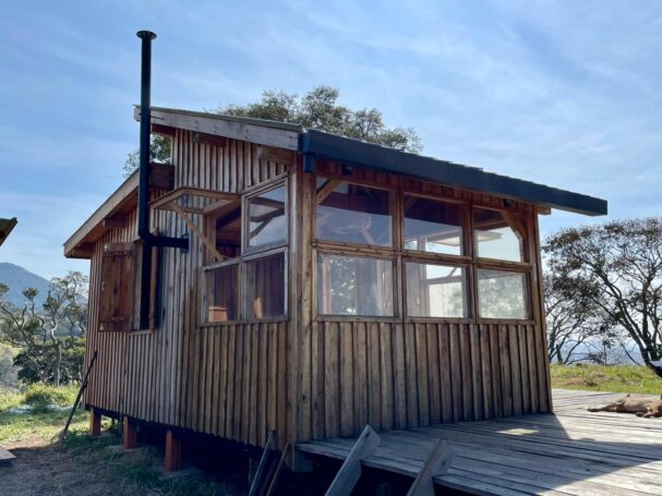 Off-grid tiny house exterior with wooden siding and deck