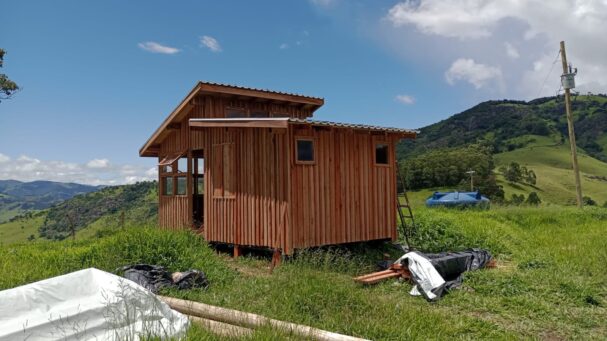 Off-grid tiny wood cabin exterior built in a rural mountain landscape